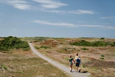 Paar spaziert entlang der Dünen auf Spiekeroog