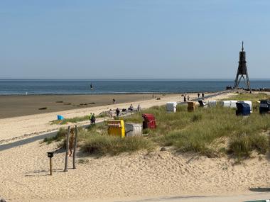 Stempelbox vor Strandkörben und der Kugelbake am Strand in Cuxhaven