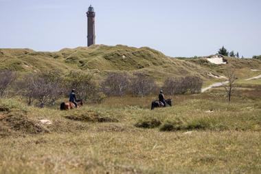 Fahrradfahren durch die Dünenlandschaft am Leuchtturm auf Norderney