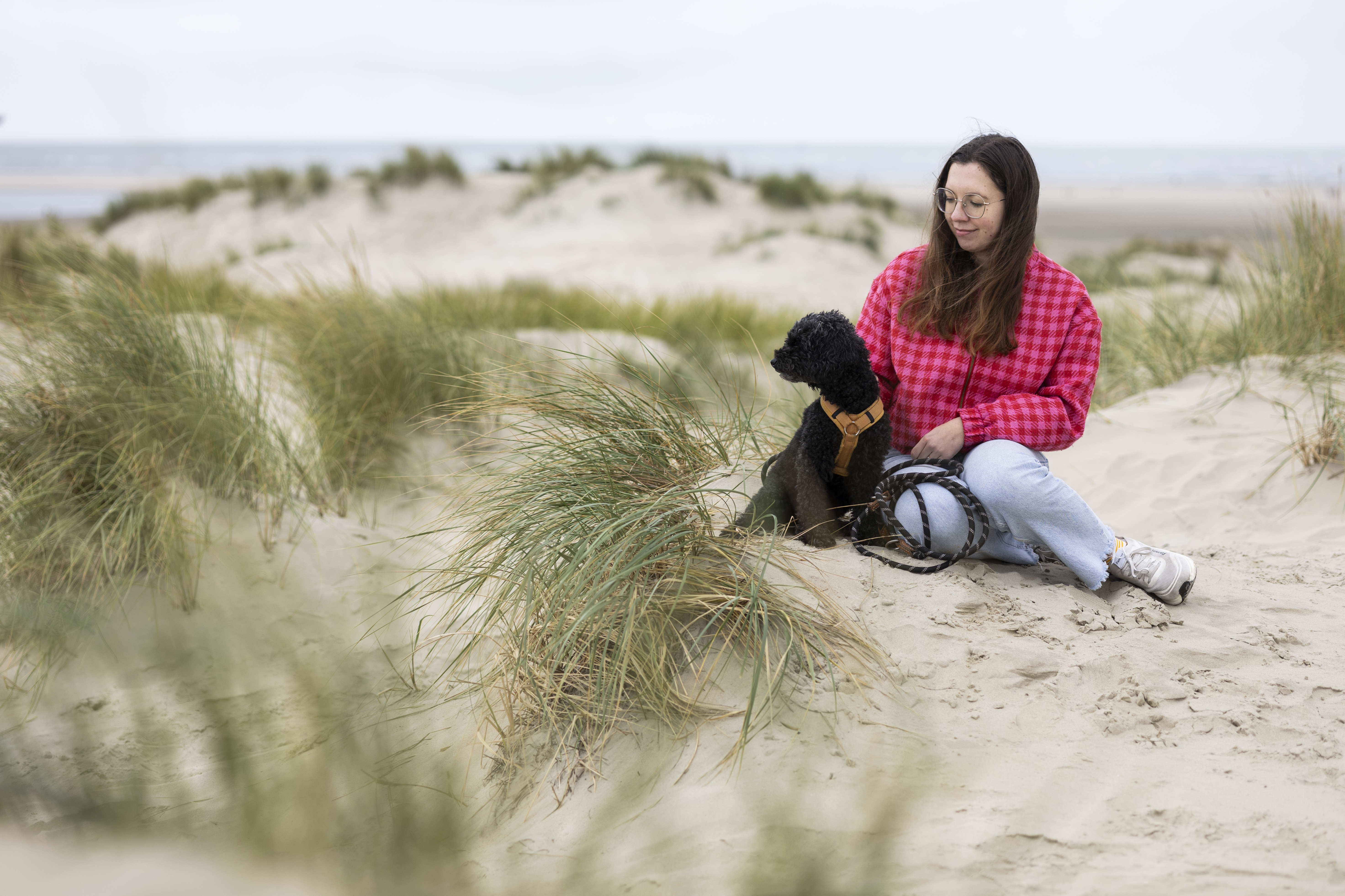 Frau mit Hund bei einem Spaziergang am Strand von Borkum